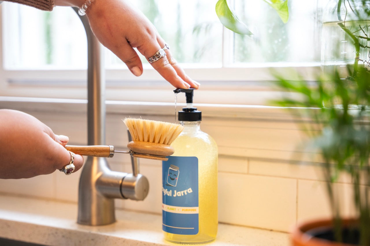 Clean dish soap and long handled bamboo dish brush with replaceable head made with agave plant fibers